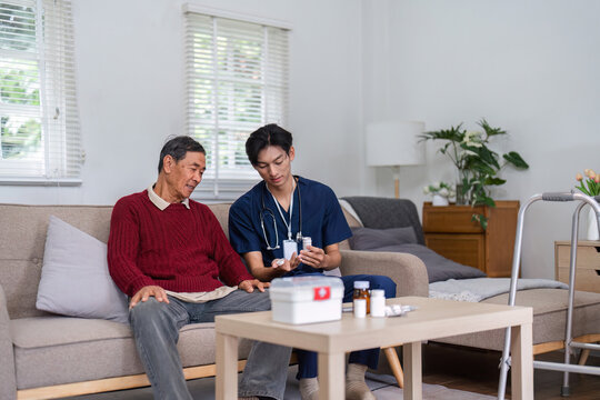 Nurse explaining medication to elderly patient during home visit in cozy living room