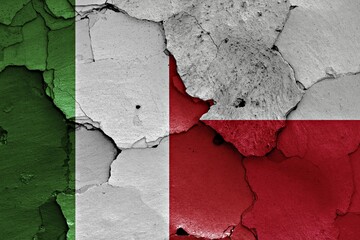 Flags of Italy and Poland painted on cracked wall