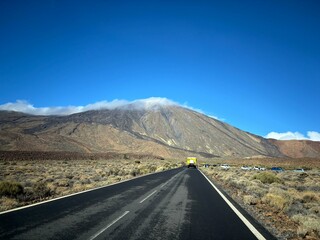 Teide National Park view with the road and volcano Teide with a white cloud over it, Tenerife, Canary Islands, Spain