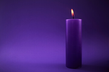 Beautiful burning violet candle on violet background