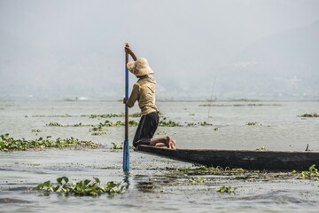 Local fishermen rowing from knees on fishing boat, Inle Lake, Shan State, Myanmar, Asia