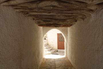 Tunel blanco con techo de madera en el pueblo de Apeiranthos en Naxos, Grecia