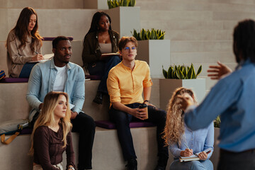 University students listening to teacher giving lesson in modern auditorium