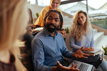 Businessman leading meeting with creative team in modern office