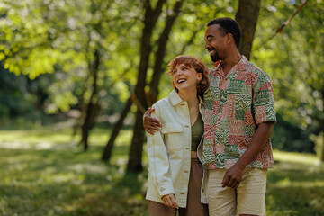 Naklejka premium Couple standing and smiling in the park