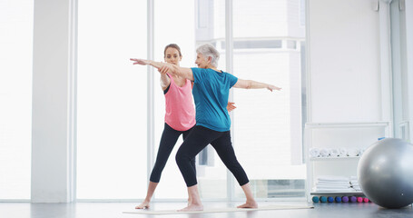 Yoga, coach and help woman with stretching for fitness, body health or warrior pose for senior...