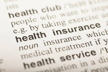 Fototapeta premium Health insurance, text in dictionary. macro shot. selective focus