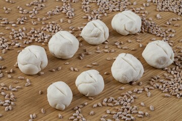Dough shaped into rolls, wheat grains