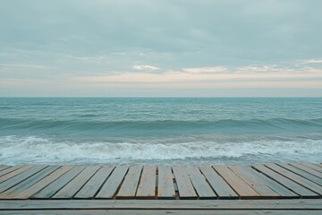 Fototapeta premium Wooden boardwalk meets tranquil ocean waves. Perfect for travel, serenity, or coastal themes.