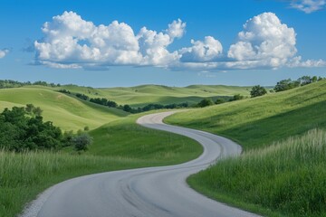 Fototapeta premium A scenic view of a winding road surrounded by lush green hills and blue skies with fluffy clouds.