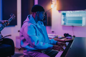 Musicians in a modern recording studio, focused on creating music together. The atmosphere is vibrant and creative, emphasizing collaboration and artistic expression in a professional environment.