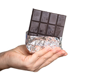 a bar of delicious chocolate in a woman's hand on a light background.