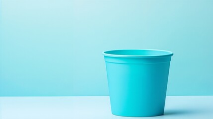 Turquoise bucket on matching background with copy space. Ideal for minimalist design, household items, and cleaning supplies.
