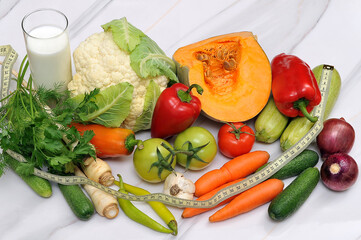 Fresh vegetables on a kitchen table with a glass of milk
