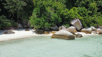 Stunning tropical beach with crystal-clear waters, white sand, and natural rock formations. A...