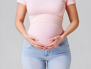Pregnant Woman Holds Her Belly Gently in Pink Shirt and Blue Jeans, Close-Up Photo on White Background.