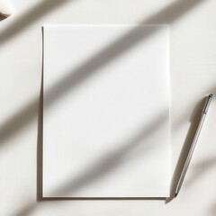Blank canvas cradled in sunlight with gentle shadows and a silver pen resting beside it