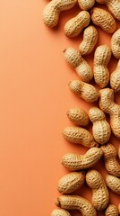 Peanuts in shell on orange background.