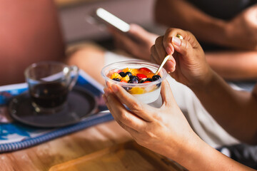 Woman eating delicious Panna Cotta with berries.