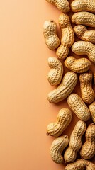 Shelled peanuts arranged on the right side of a light orange background.