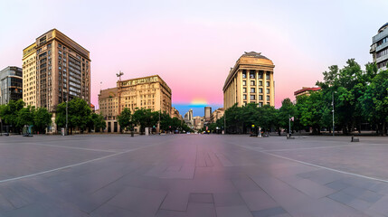 City Square Showcases Buildings, Trees, and Pastel Sunrise with Rainbow Arching Across Sky