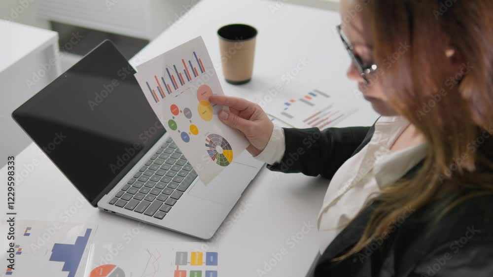 Poster A skilled professional is carefully analyzing financial data using clear graphs and detailed charts while working in a vibrant and modern workspace that promotes productivity and focus