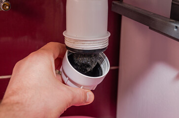 A plumber cleans a clogged sink drain