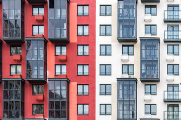 Contemporary apartment buildings with beige and red facades, featuring numerous balconies with...