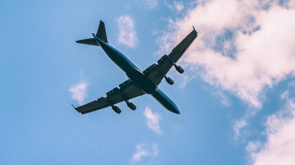 Fototapeta premium Low angle view of an airplane in flight against the sky, perfect for aviation, travel, transportation, and adventure-themed concepts, Generative AI