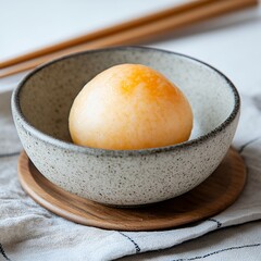 Close Up of Single Round Pale Orange Dessert in Speckled Gray Bowl