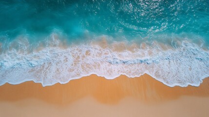 Aerial view of turquoise ocean waves breaking on a sandy beach.
