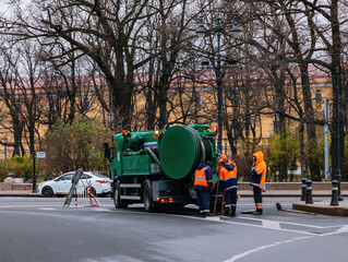 Sewer workers cleaning manhole and unblocking sewers