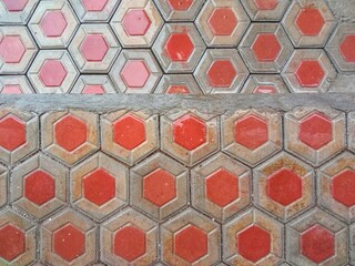 Hexagonal red and grey floor tiles with a wet and shiny surface. Seamless pattern.