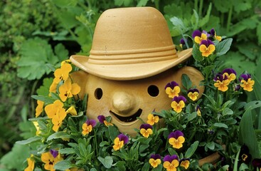Garden figure with pansies, gardener with hat, flower garden