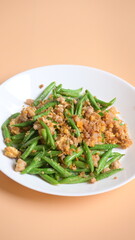 fried green bean with pork on white plate, thai and chinese food