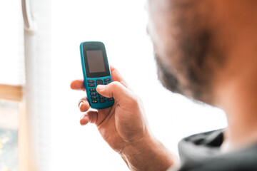 Man hold a dumbphone. An old phone. Digital minimalism concept.