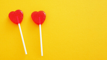Two red heart shaped lollipops as symbol of valentine day celebration. Strawberry flavoured candies. Ideas for 14 February greeting. Space for text
