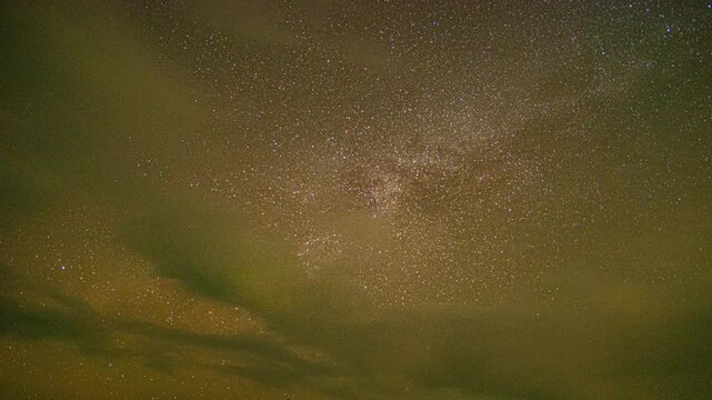 Time lapse Milky Way on a cloudy night. The long night saw the Milky Way begin to perpendicular to the sky. Clouds followed by, obscuring the sky and stars. The night sky sparkles with stars.