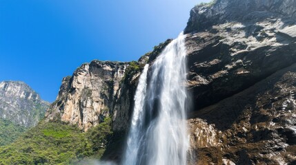Obraz premium High Waterfall Cascading Down Rocky Cliff Face