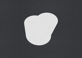 Two plain white oval papers on a black background, Blank white Business card mockup stacks at grey textured paper background