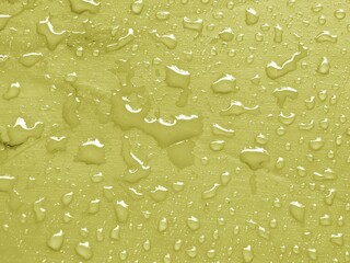 Water drops on limelight colored metallic surface