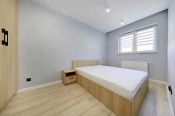 Sypialnia w nowoczesnym apartamencie z dużym  materacem i szafą jasno brązową © arteffect.pl