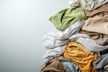 vibrant collection of discarded clothing in various colors, symbolizing waste and sustainability. arrangement showcases textures and hues, emphasizing importance of recycling textiles, fast fashion