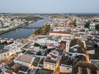 Obraz premium City view with roman bridge over Gilao river in old fishermen's town in the evening light, Tavira, drone shot, Algarve, Portugal, Europe