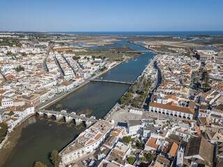 Obraz premium City view with roman bridge over Gilao river in old fishermen's town,Tavira, drone shot, Algarve, Portugal, Europe