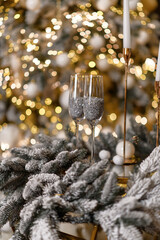 Two glasses standing on the table before the Christmas tree