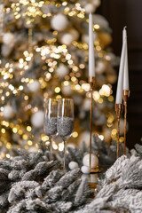 Two glasses standing on the table before the Christmas tree