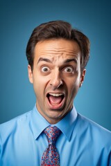 arafed man in a blue shirt and tie making a funny face
