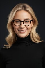 Obraz premium blonde woman with glasses smiling at camera on black background
