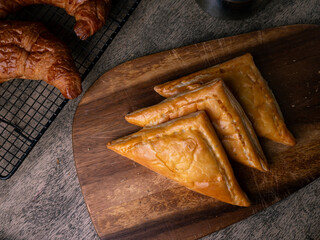 Fresh Baked puff pastry pie with filling on wooden cafe table